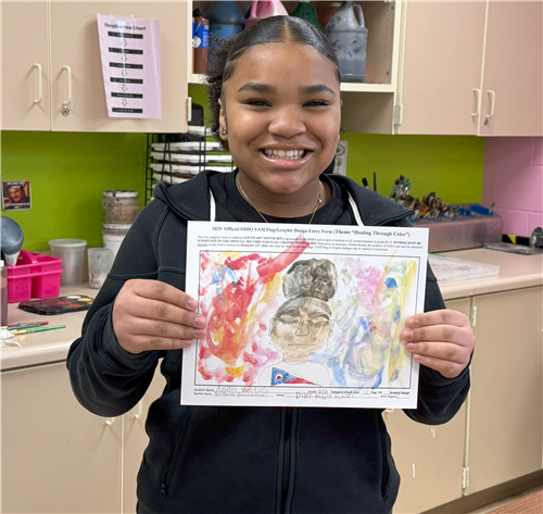  Student holding up a picture of her self portrait